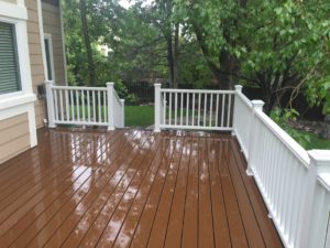 Brown deck with white railing and stairs