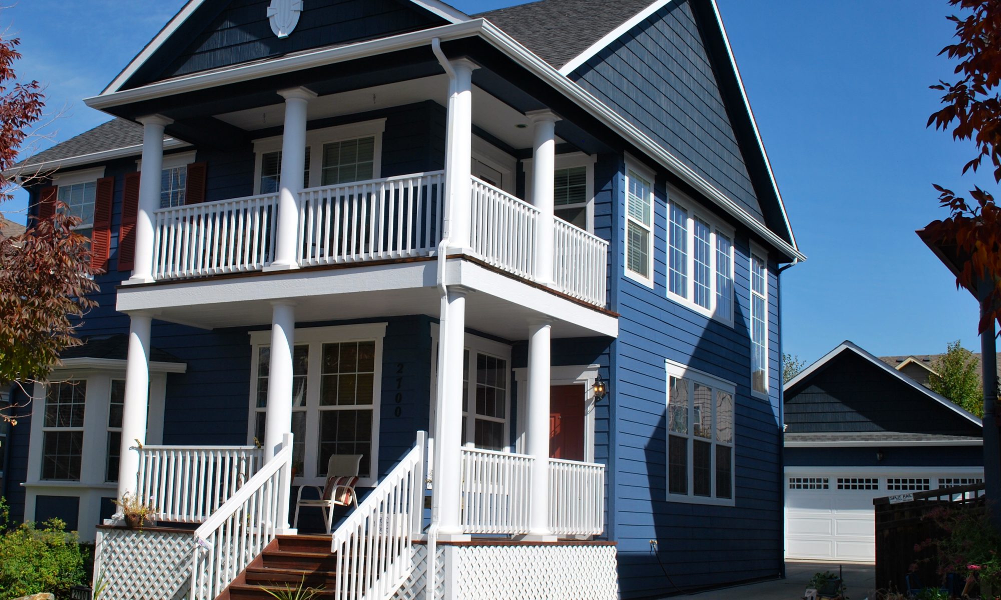 Bright blue house with white front porch - Vivax Pros